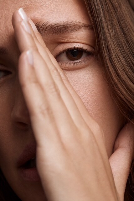 Beauty-Nahaufnahme, Hand am Gesicht, ein Auge sichtbar
