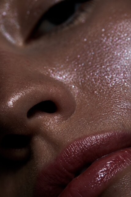 Detail: Lippen in Beerenton auf glänzender Haut