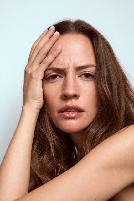 Portrait mit Hand an der Stirn, direkter Blick